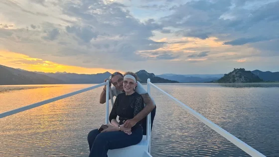 A couple on the bow of the boat at sunset on Skadar Lake