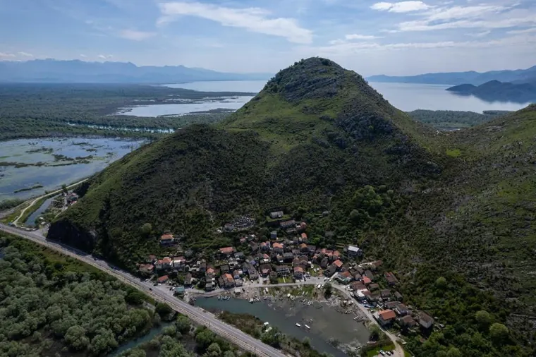 Aerial of the village beneath its hill on the lake