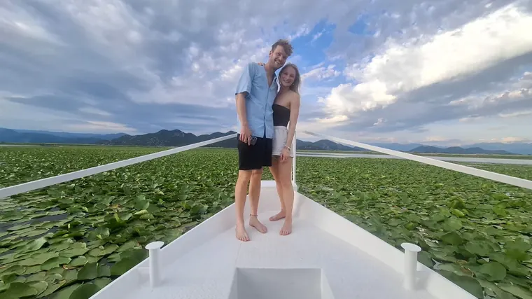 A couple standing on the bow amid the lilies