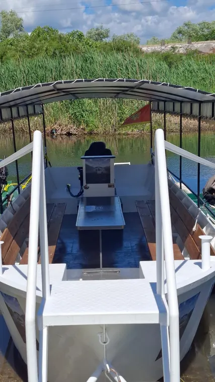 At the helm of the boat on the lake