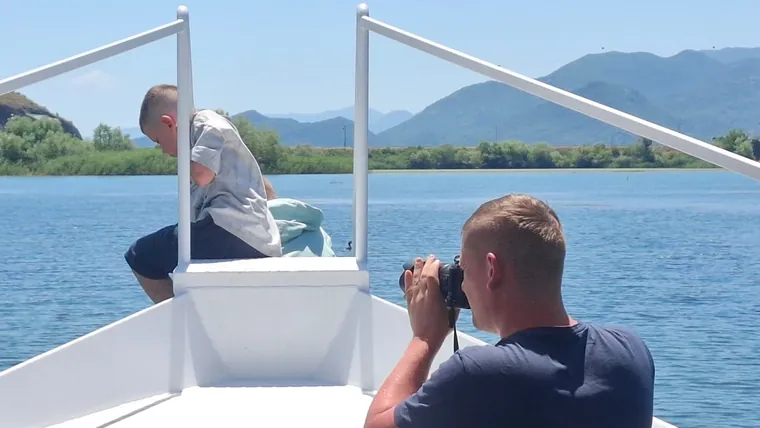 A guest photographing the lake from the bow
